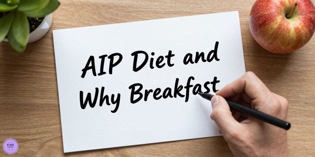 Handwriting "AIP Diet and Why Breakfast" on paper. Nearby are a red apple and a potted plant on a wooden table, conveying a healthy lifestyle theme.