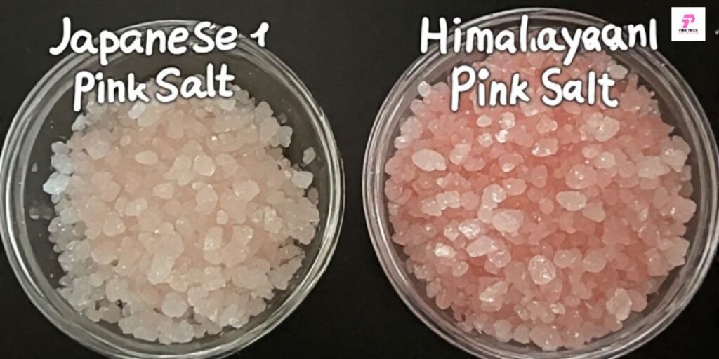 Two bowls of pink salt are displayed on a black background. The left bowl contains Japanese pink salt, and the right bowl contains Himalayan pink salt.